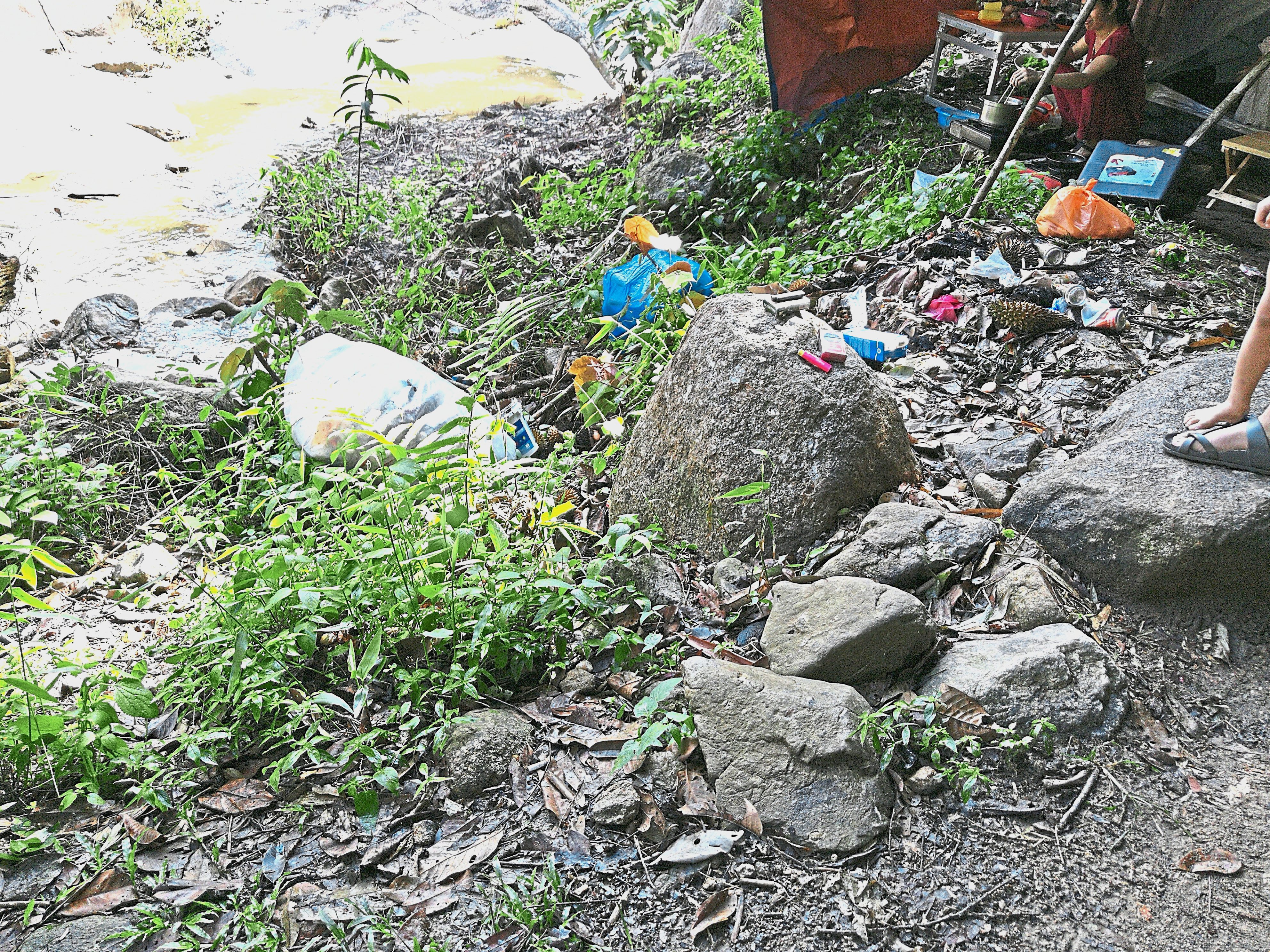 A pile of rubbish left right next to the stream near the campsite.