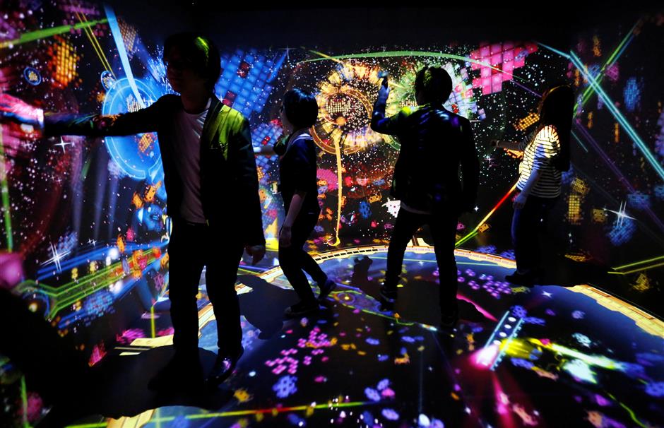 ?People play the VR attraction Bahamut Disco feat. Space Invaders during the preview event of the Play! Space Invaders Exhibition to celebrate the 40th anniversary of the game in Tokyo, Japan, January 11, 2018.  REUTERS/Toru Hanai