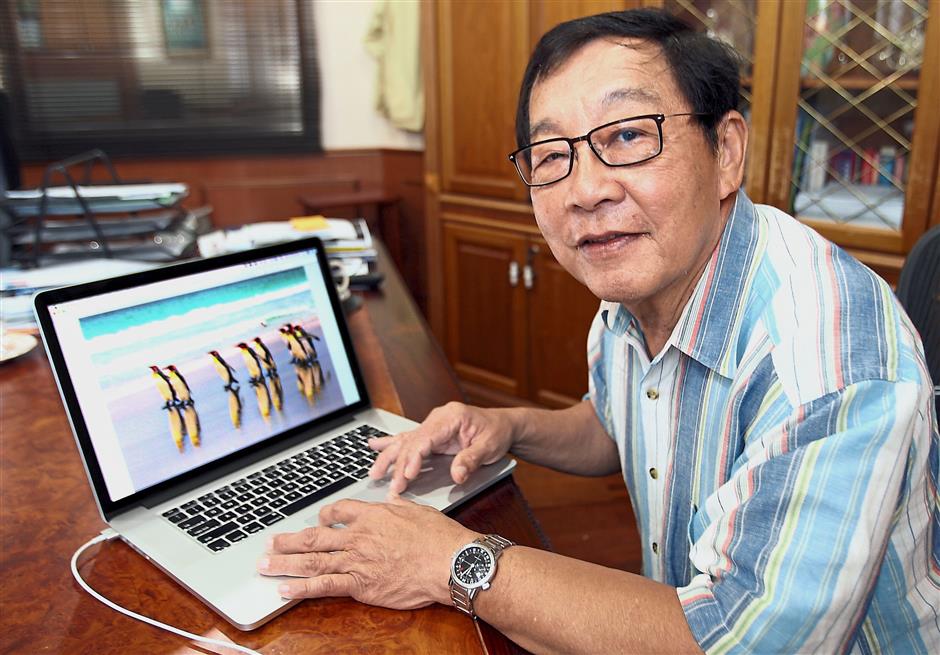 Fong with one of his pictures of the King penguin of Antartica. — S.S. KANESAN/The Star