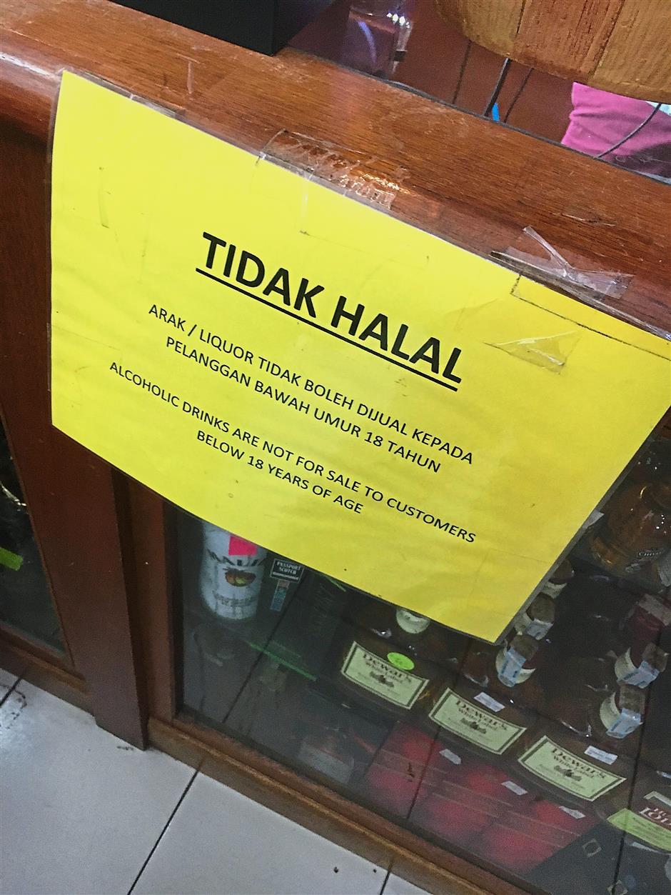 This shop is still displaying the old notice even though the age limit for buying alcohol is now 21 years old.