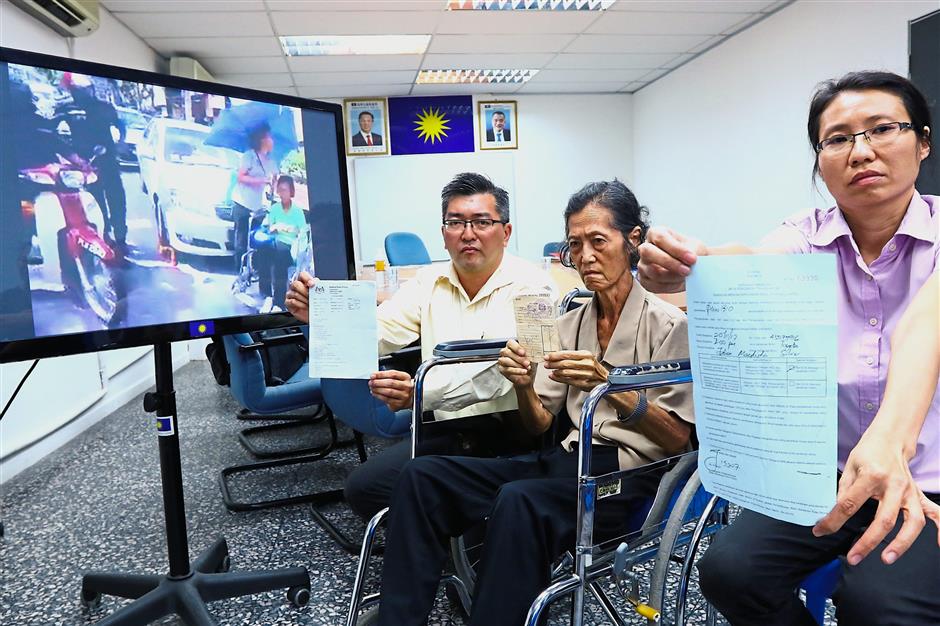 Chee Lin showing the summons issued by the council while Teoh holds the receipt at the press conference. With them is Teck Liang (showing Teoh’s medical report).