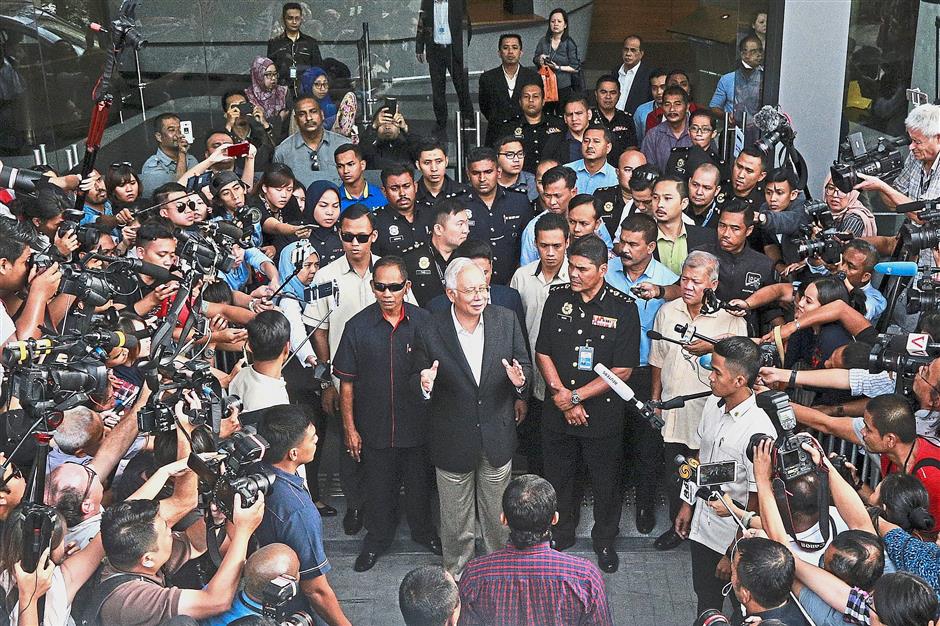 Sea of reporters: Najib speaking to pressmen on his way out of the MACC  headquarters in Putrajaya after a six-hour questioning session. — AP