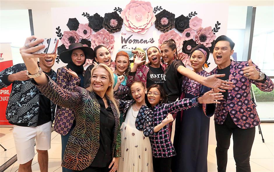 Smile for the camera: Malaysian fashion designer Rasta Rashid (holding phone) and her models were at the Women’s Fiesta at Starling Mall, Damansara Uptown, to showcase her Batek RTW collection.