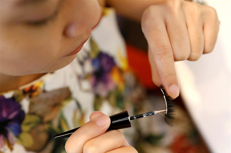 A woman puts glue on fake eyelashes by e-commerce brand Bohktoh in Bangkok, Thailand June 12, 2019. Picture taken June 12, 2019. REUTERS/Jiraporn Kuhakan NO RESALES. NO ARCHIVES. NO RESALES. NO ARCHIVES.