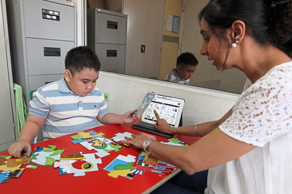 Dr Susheel uses apps during her therapy session to help her student develop speech. — GLENN GUAN/The Star