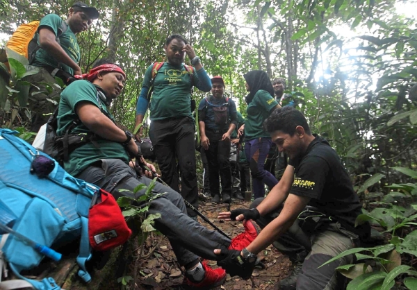 Hikers helping an injured teammate during the climb.