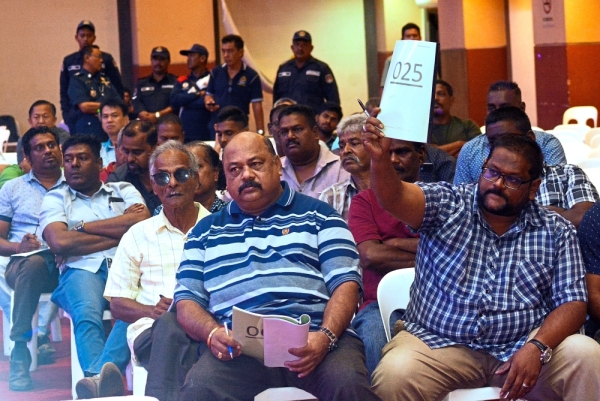 Some of those who took part in the public auction by DBKL for abandoned vehicles and oBike yesterday, and (right) a filepic of the oBikes piled up in DBKL’s depot in Cheras that were auctioned off to a single bidder.