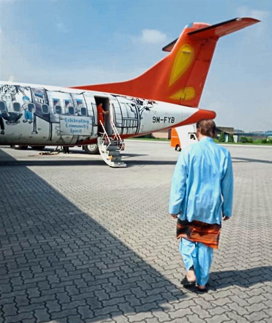 Flying coach: Anwar walking towards the aircraft bound for Penang. — Photo taken from Facebook
