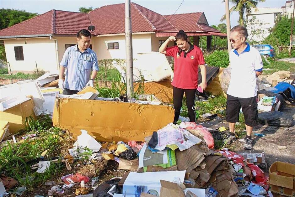 Low ?(left) checking an illegal dumpsite in Kampung Tersusun Bercham, Ipoh.