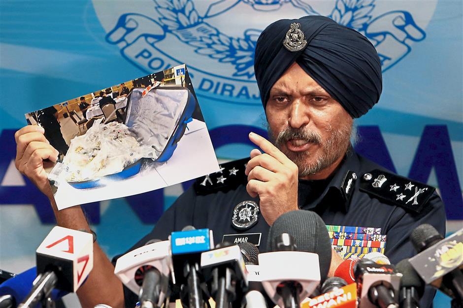 Amar Singh, head of Malaysias Commercial Crime Investigation Department (CCID), displays a photo of items from a raid during a news conference in Kuala Lumpur, Malaysia June 27, 2018. REUTERS/Lai Seng Sin
