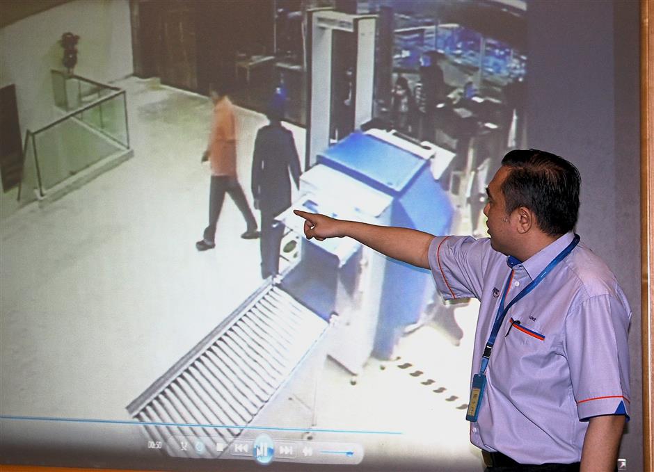 Making a point: Loke pointing to video footage of Vigneswaran walking in the VIP lane while wearing sandals.
