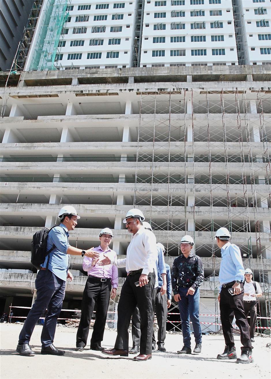 Going up: Jagdeep (in white) making his site visit to the Chelliah Park City housing project in George Town.