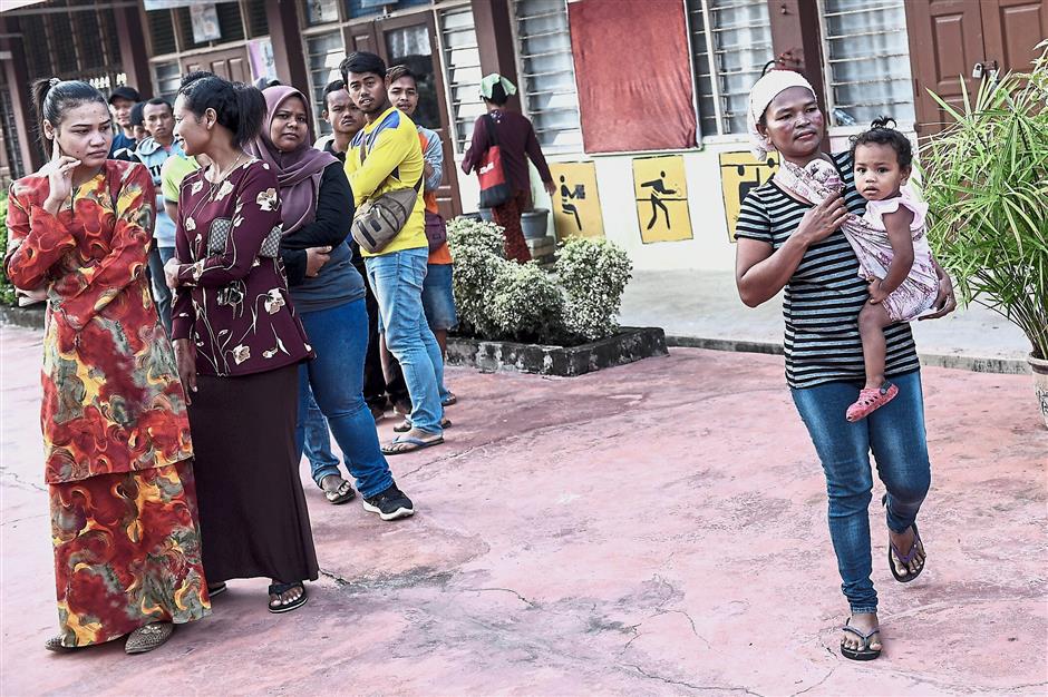 Patiently waiting: Orang asli voters lining up to cast their votes at SK Tanjung Gahai in Cameron Highlands. — Bernama