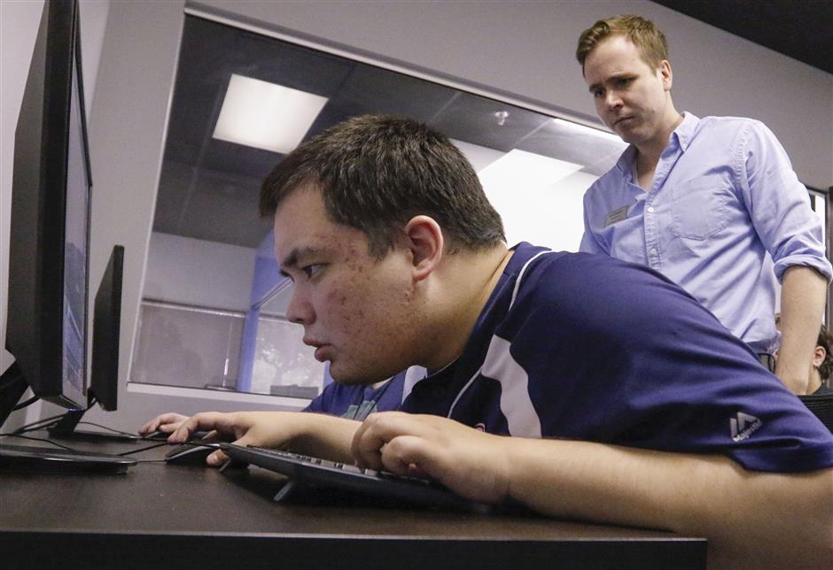Kyle Barton, standing, who is on the autism spectrum, is a graduate and instructor at the nonPareil Institute in Plano, Texas. He works with Iain Morrison on Wednesday, May 2, 2018 in the Unreal World Builder I class. Students learn a software used to create video games in the class. The nonPareil Institute, a non-profit, helps adults with autism through technical, vocational and social training. (Ron Baselice/Dallas morning News/TNS)