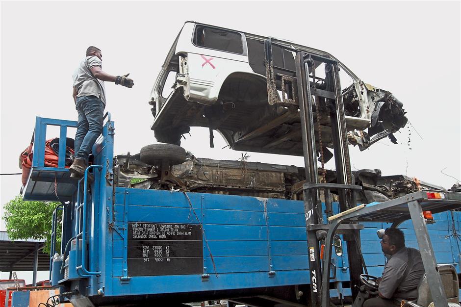 An abandoned car being loaded into a truck at the depot.