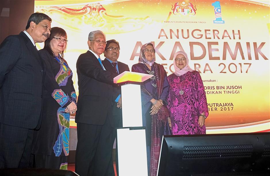 Greater heights: Idris (third from left) launching a coffee table book on ‘Cendekiawan Terbilang’ during the awards ceremony at Putrajaya. With him are Dr Yap (second from left) and Dr Siti Hamisah (second from right). — Bernama