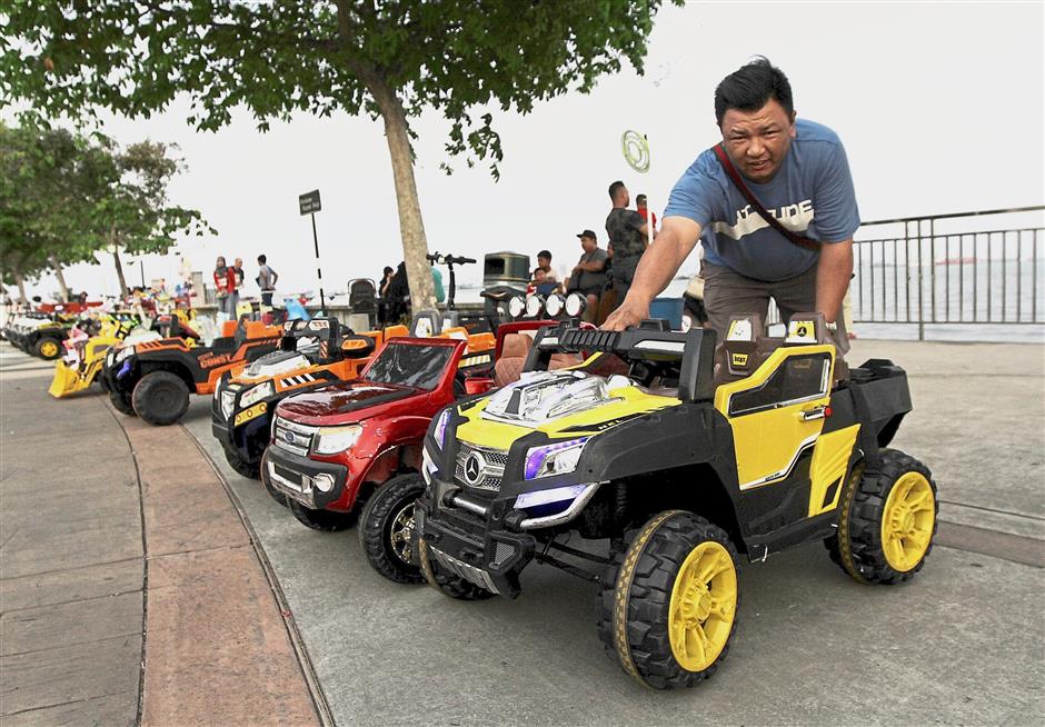 Loh arranging the toy cars that he rents out at the promenade.
