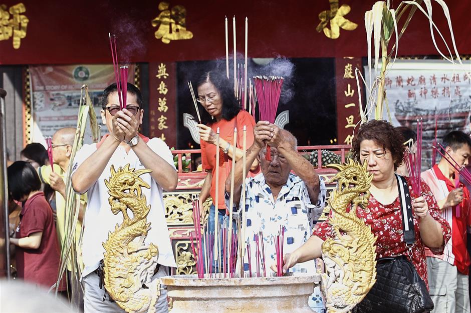 Devotees praying with joss sticks at the Snake Temple to commemorate the resident deity Cheng Chooi Chor Soo Kong’s birthday.