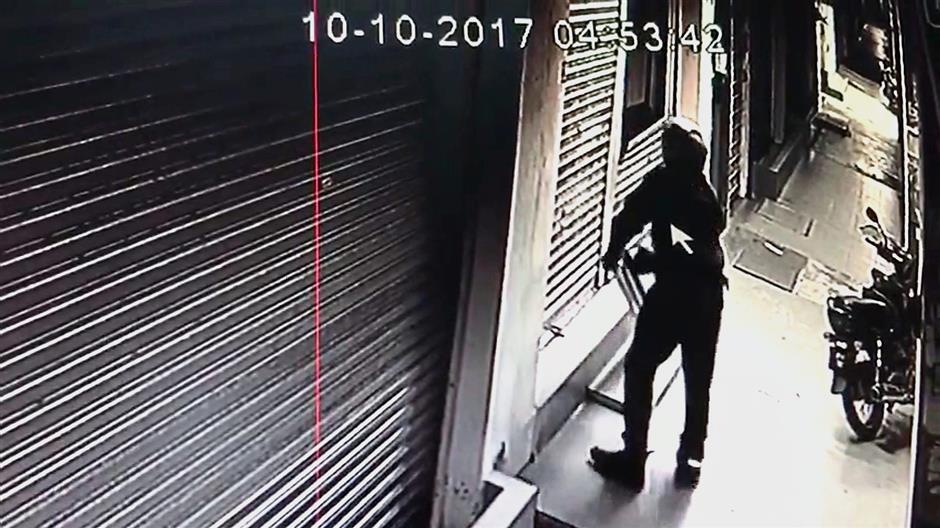 After successfully dismantling a section of the shutter, the thief enters the premises through the window he created.