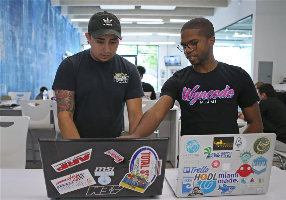 Wyntalent UX designer and Teaching Assistant Calvin Simms works with one of the students Cristian Ospina at the Wyncode Academy on Wednesday, July 18, 2018, in Miami. (David Santiago/Miami Herald/TNS)