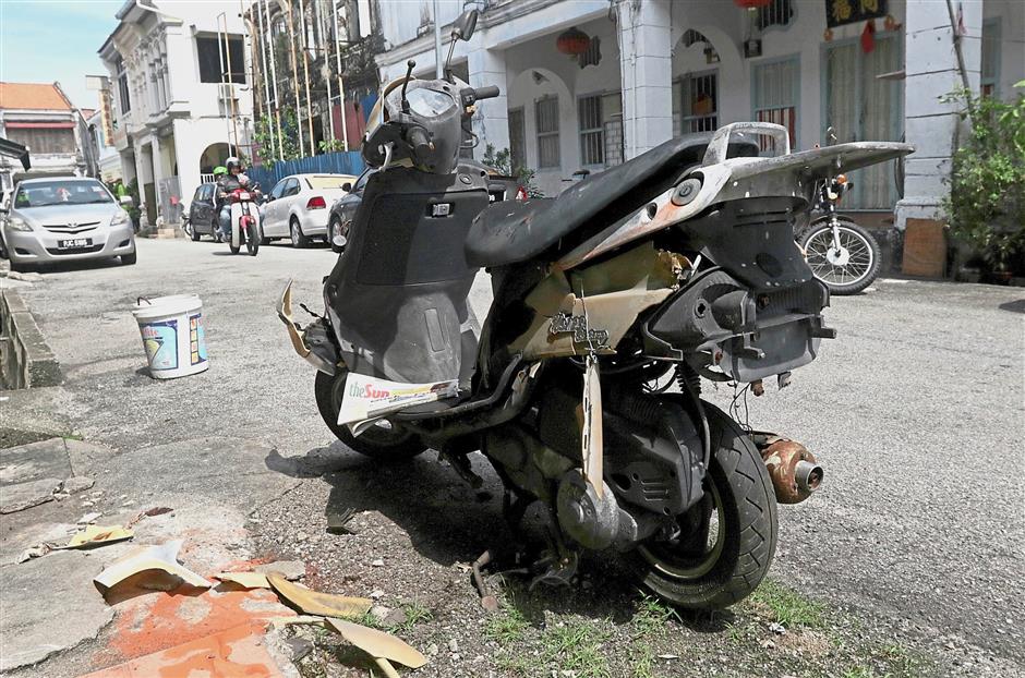 A motorcycle found collecting rust at Lorong Chulia.