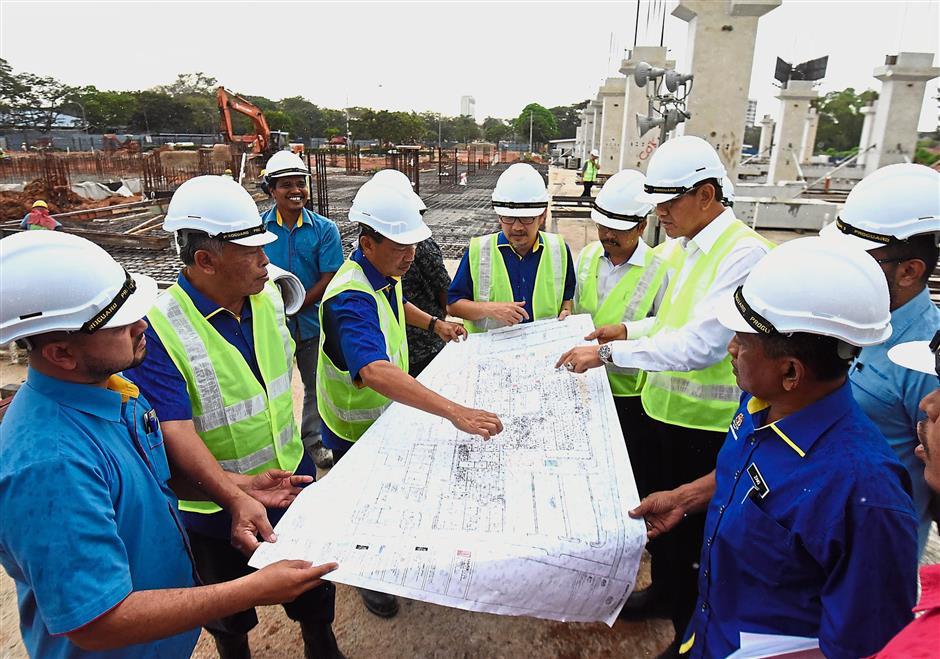 Zainal (second right) looking at the upgrading plan for the Seberang Jaya Hospital during a site visit.? (Left pic) Construction is ongoing for a new multi-storey block that can accommodate 300 more beds. It will also provide cardiology and paediatric cardiothoracic services as well as rehabilitation medicine.