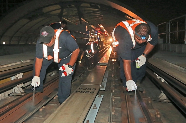 TNMD staff lubricating the rails and track during a re-greasing turn-out process.