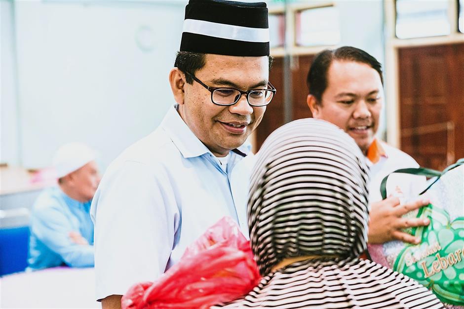 Straight to work: Akmal greeting a resident of Flat Larkin in JB.