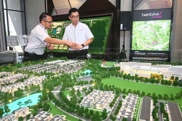 Chu (left) and Aw looking at a model of twentyfive.7.