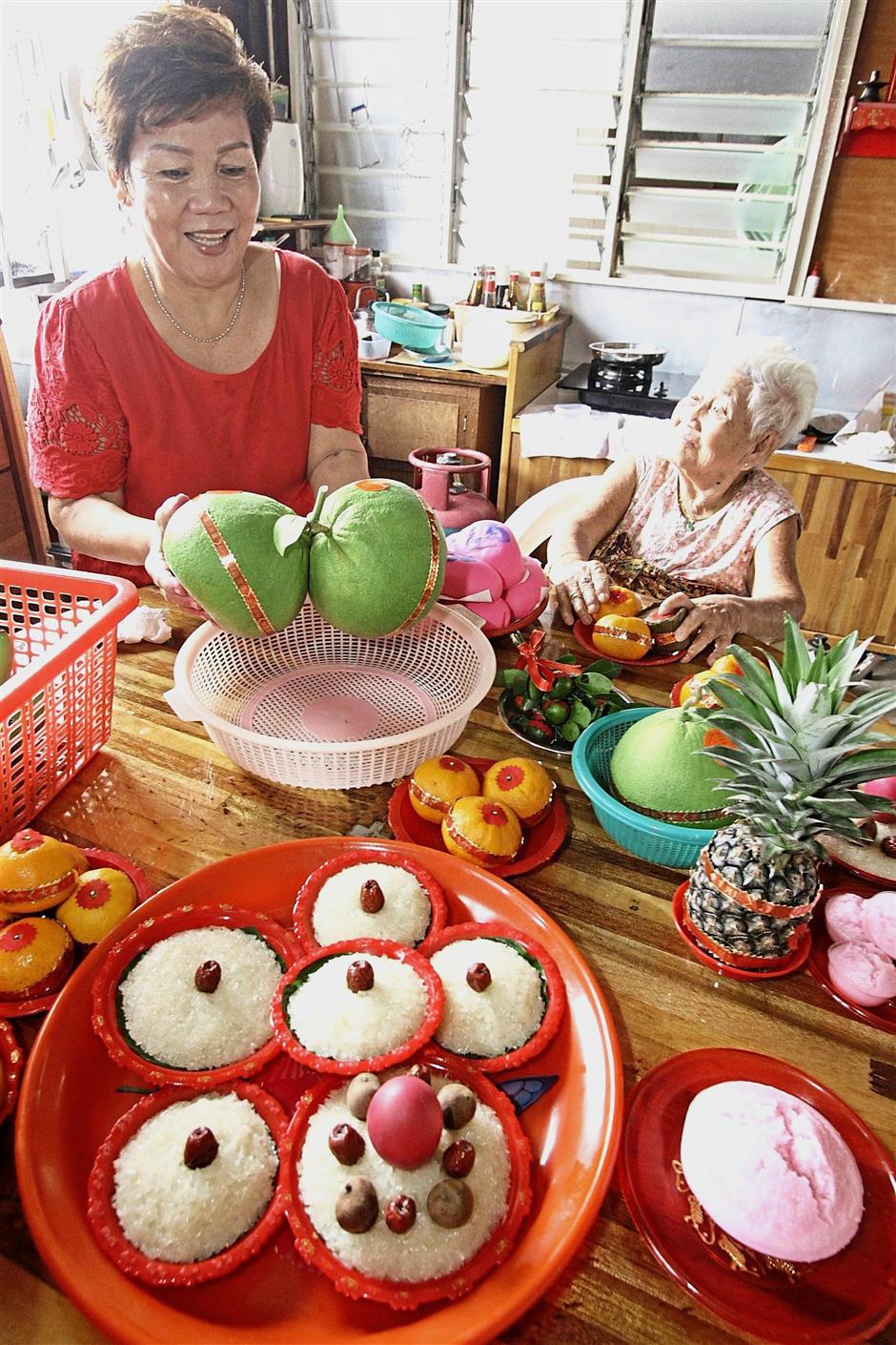 (BRIEF CAPTION): Chew Jetty residents Lee Chooi Har, 62, preparing the foods and fruits for the celebration of Jade Emperors annual birthday with her mother in law Lim Ah Koay, 91, at Chew Jetty./Picby:CHAN BOON KAI/The Star/23 February 2018.