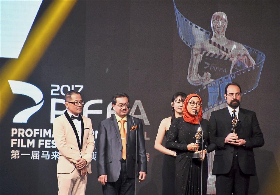Jury Awards winner Tunku Mona Riza (in headscarf) delivering her speech while fellow winner Mohammadreza Shams (right), PIFFA 2017 vice-president Sam Leong (left) and PIFFA 2017 adviser and Finas director-general Datuk Fauzi Ayob (second from left) look on during the Profima International Film Festival and Awards 2017. — Photos: SYED AZAMUDDEN/The Star