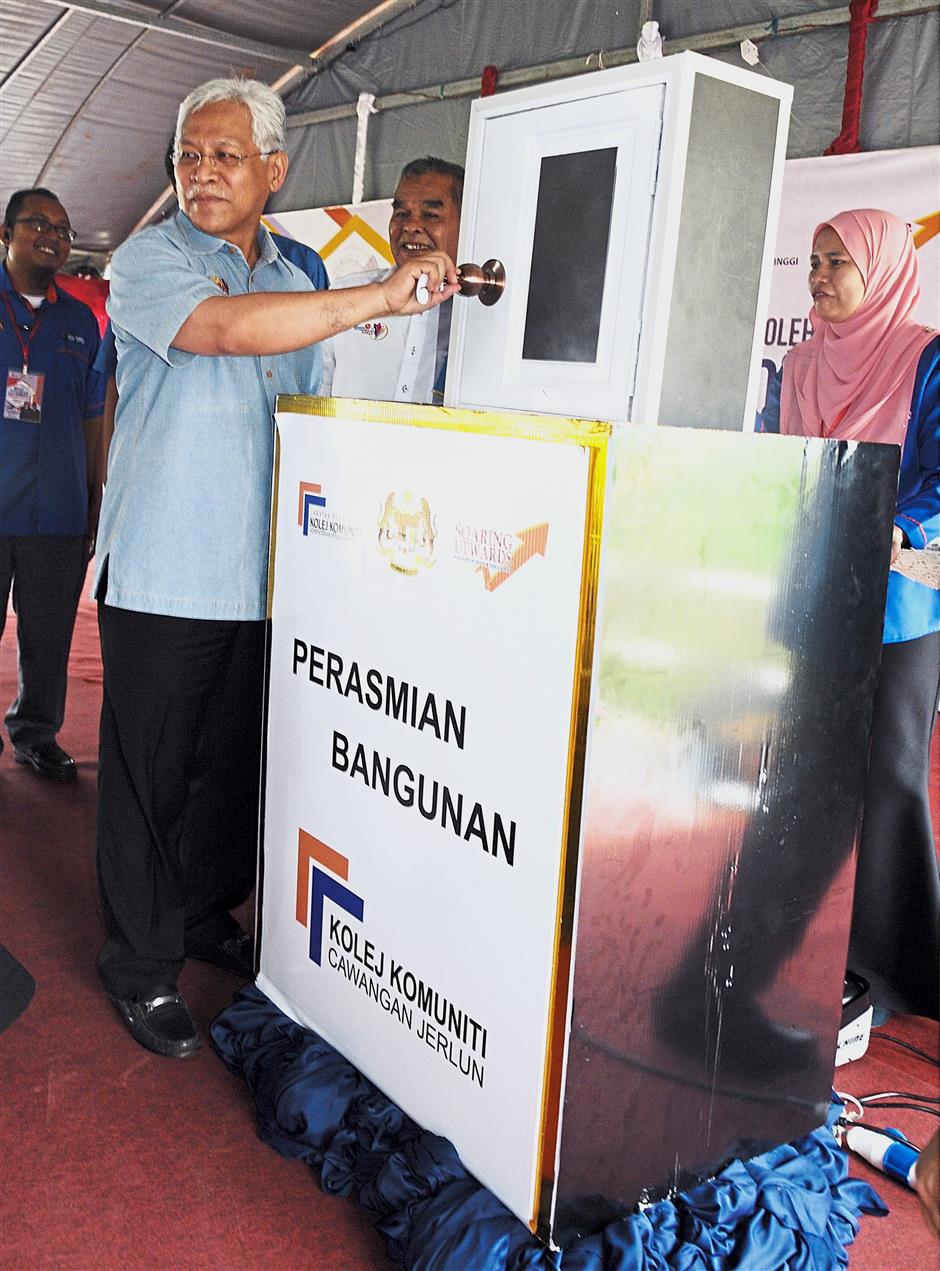 Higher Education Minister Datuk Seri Idris Jusoh (left) used a mocked key to open a mocked door to officially opened the Kolej Komuniti Jerlun Branch in Jerlun, Kedah yesterday.(Starpic by G.C.TAN/The Star-10th APR 2018)
