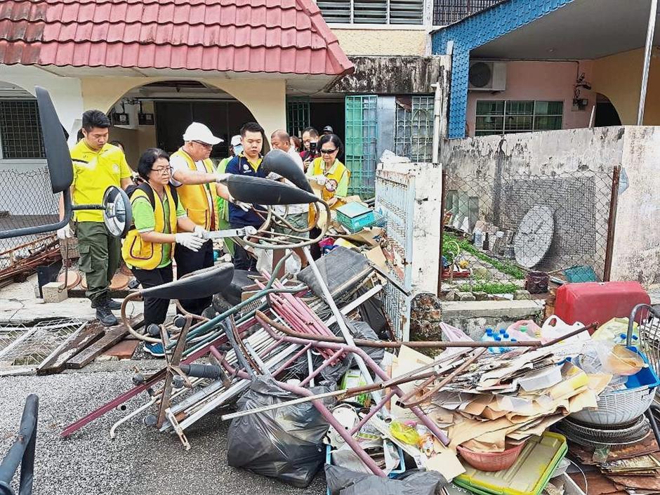 Dr Ng (wearing a cap) is seen here with his team helping to clear junk from a hoarder’s house in Ipoh with the owners approval. — filepic