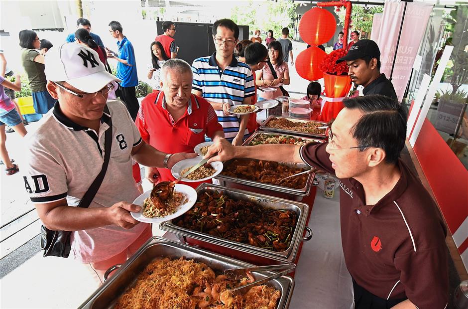 Teoh serving food to guests during the open house.