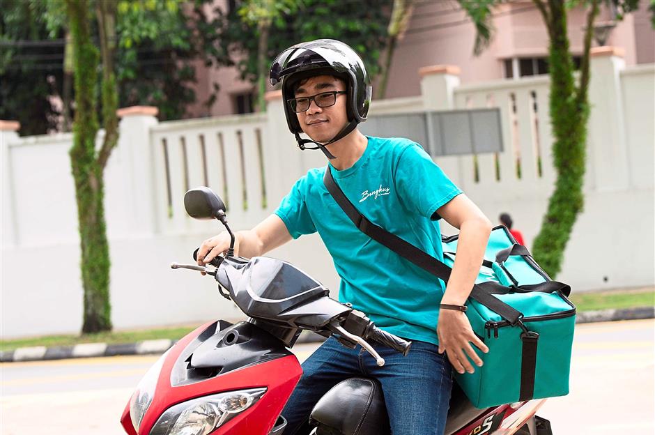 A Bungkus by Honestbee rider only delivers food items from halal-certified merchants. — Honestbee