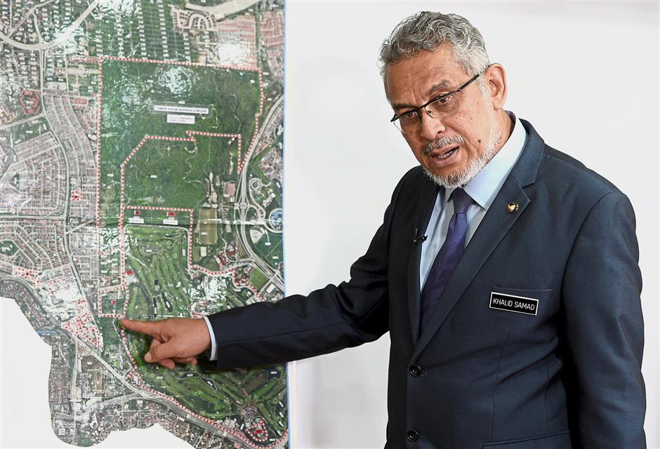 Khalid showing the area of the proposed development at Taman Rimba Kiara during the interview.