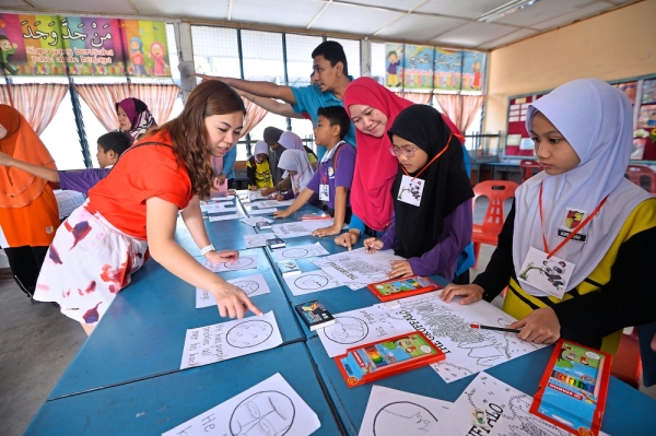 HSBC volunteers conducting the fun activities for pupils and parents to encourage literacy.