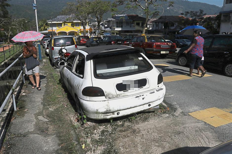 A badly stained car seen at the roadside near Semarak Api FarIim Pocket Park in Bandar Baru Ayer Itam.
