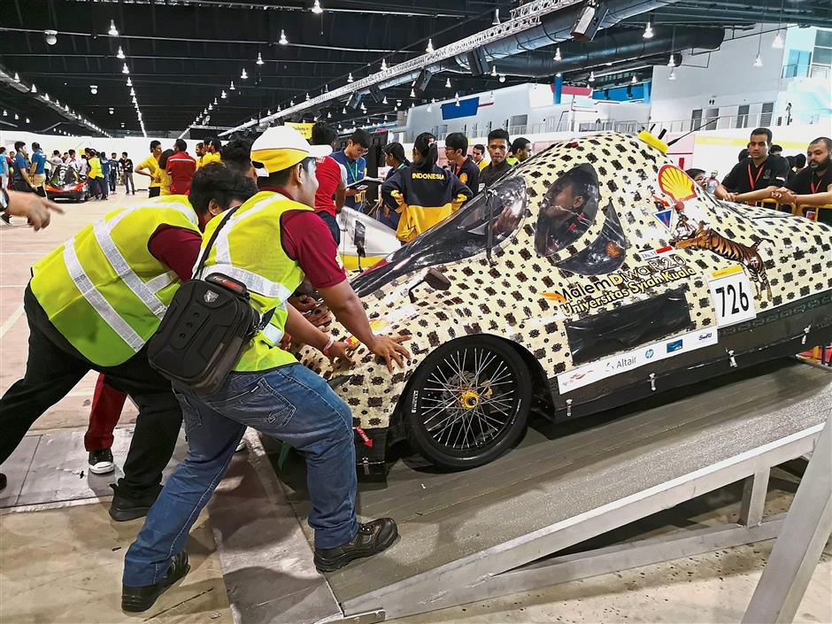 Team members from Indonesia positioning their Urban Concept vehicle before undergoing the brake test.
