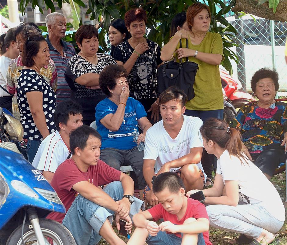 Overwhelmed: A relative of one the victims of the Sungai Long fire overcome by emotion at the scene.
