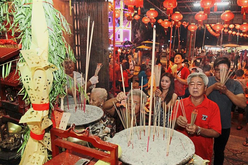 Devotees offering prayers to the Tua Pek Kong before ‘listening’ to the deity’s forecast of the state’s economy.