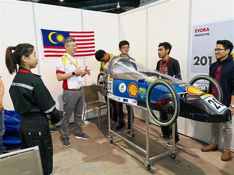 Lo (second from left) speaking to Universiti Malaya students with their hydrogen-powered vehicle.