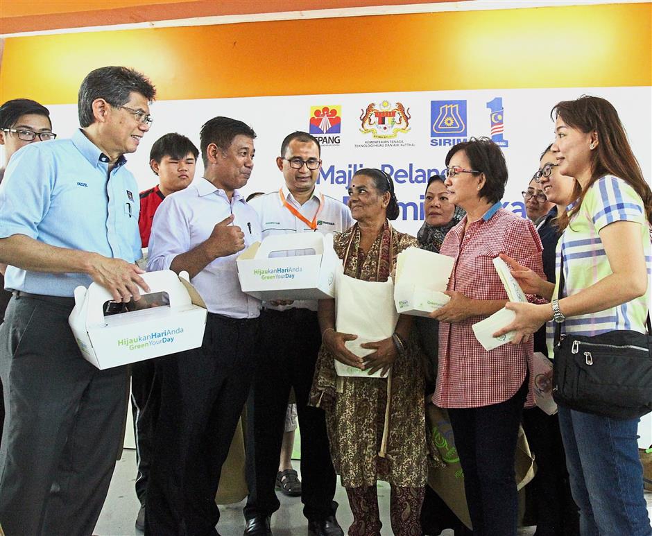 (From left) Prof Ahmad, Puasa, and Asdirhyme presenting food traders operating at the Dengkil Food Court with Sirim’s brand of biodegradable packaging at the launch of the green food premises pilot project in Dengkil