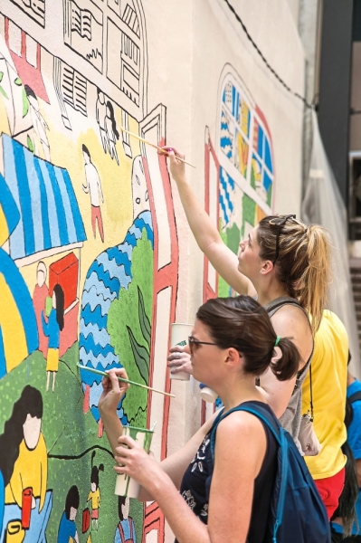 Visitors painting a mural along Lorong Bandar 13 which is now a bright and welcoming place.