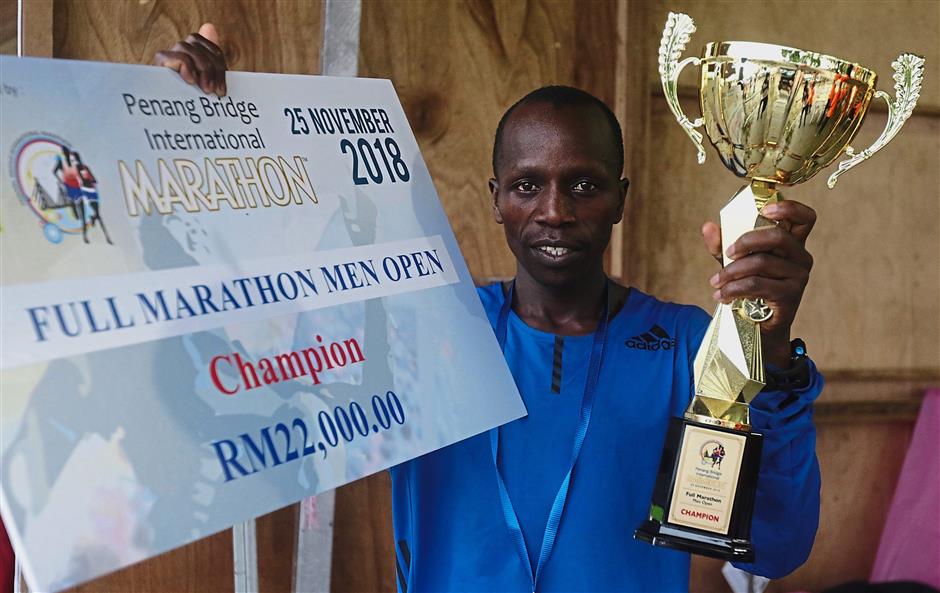 (Left pic) James from Kenya showing off his prizes for winning the Full Marathon Men’s Open while (right pic) Nik Fakaruddin and Loh won the Best Malaysian categories.