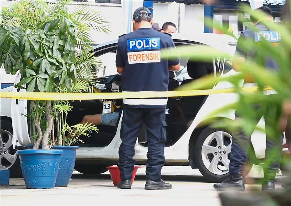 Bizarre situation:? Investigators ?examining the suspect’s car at the Damansara police station, with the victim in the front seat.