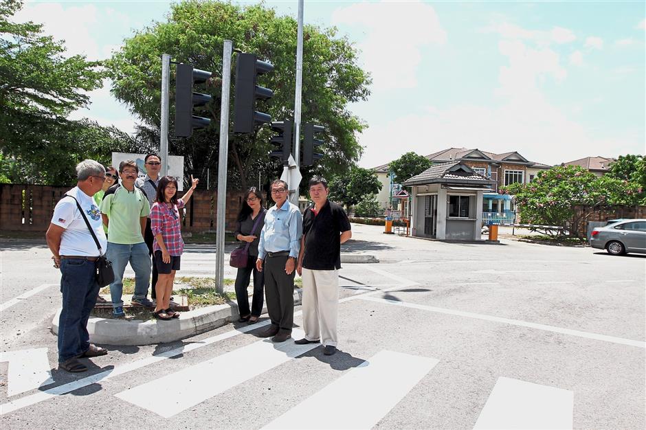 Jackie Chew (centre) and her team are active in addressing problems such as faulty traffic lights in Kota Kemuning. — filepic