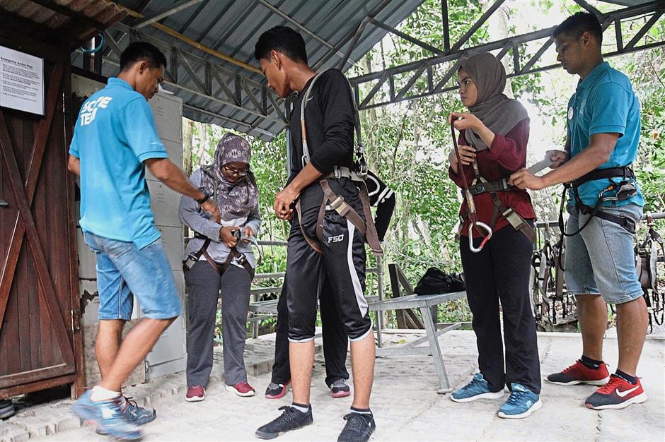 Ride attendants (in light blue) briefing participants before they make their way to the ziplines at the Flying Lemur.