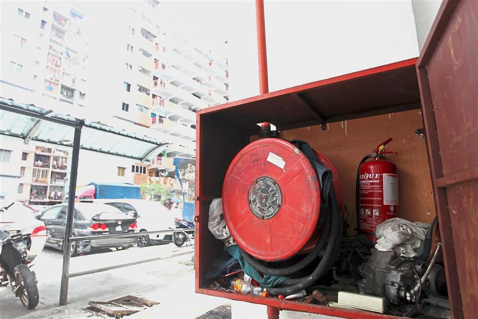 Lack of maintenance on fire fighting equipment such as this hose reel and fire extinguisher compartment at a PPR in Kuala Lumpur could have devastating consequences in case of fire. — filepic