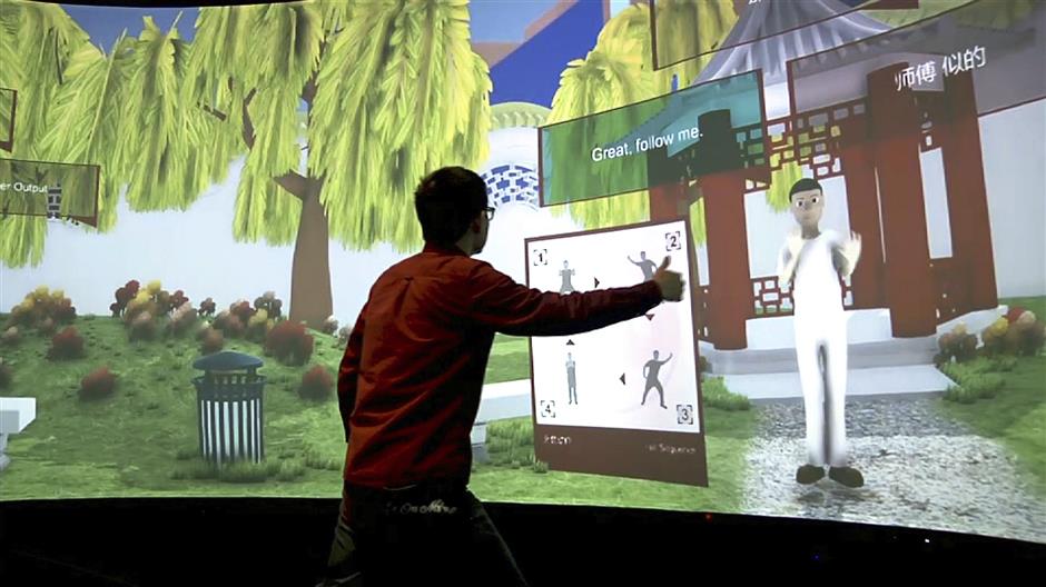 In this Aug. 22, 2018 image taken from video, Rensselaer Polytechnic Institute graduate student Xiangyang Mou practices tai chi with an avatar in a campus studio at Rensselaer Polytechnic Institute in Troy, N.Y. The 'Mandarin Project' is a joint venture of RPI and IBM. Cognitive and Immersive Systems Laboratory researchers are developing a sort of smart room that can understand students' words, answer their questions and perceive their gestures. (AP Photo/Michael Hill)